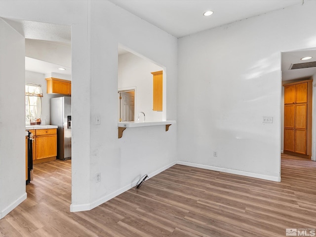 unfurnished room with lofted ceiling and light wood-type flooring