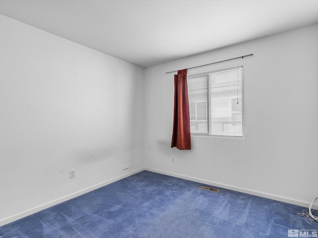 spare room with dark colored carpet