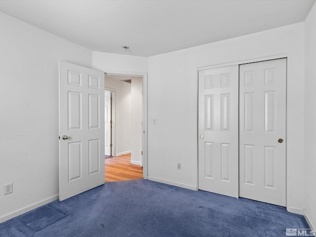 unfurnished bedroom with a closet and dark carpet