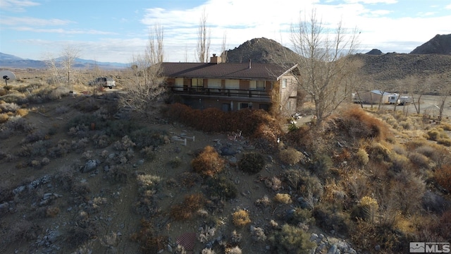 rear view of house with a balcony and a mountain view