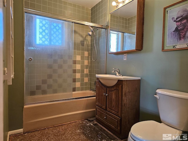 full bathroom with vanity, bath / shower combo with glass door, and toilet