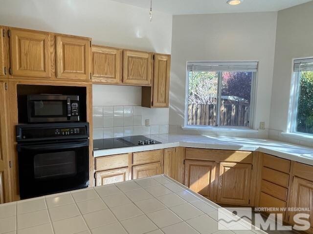 kitchen with black appliances and tile counters