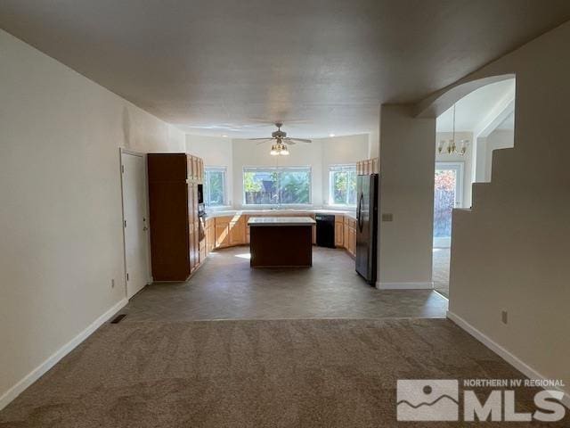 kitchen featuring ceiling fan, black fridge, and a kitchen island