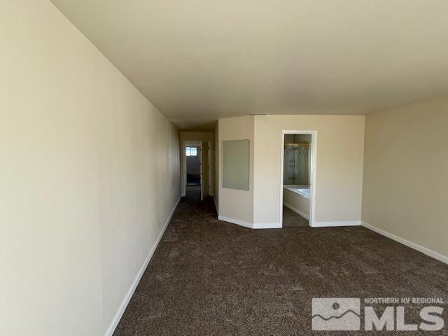 unfurnished room featuring dark colored carpet