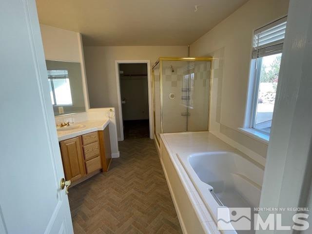 bathroom featuring parquet flooring, vanity, shower with separate bathtub, and plenty of natural light