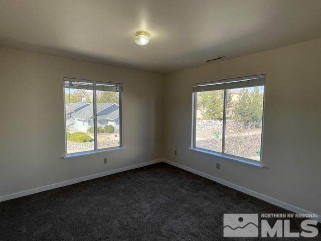 unfurnished room featuring dark colored carpet