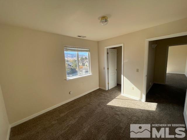 unfurnished bedroom with dark colored carpet