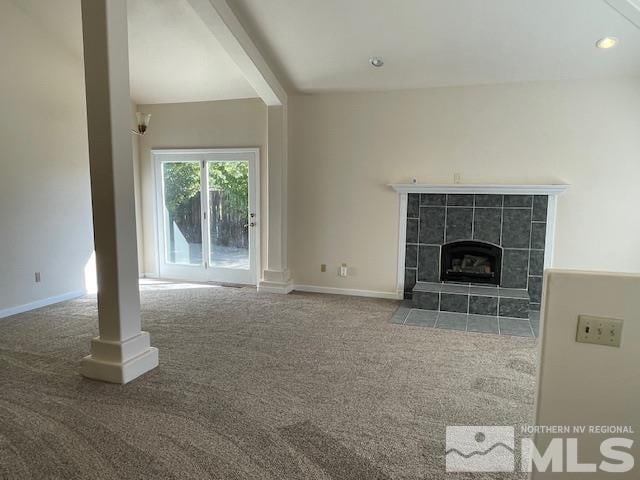 unfurnished living room with carpet flooring and a fireplace