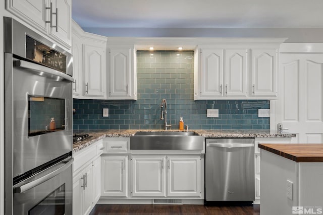 kitchen with white cabinets, stainless steel appliances, dark wood-type flooring, and sink