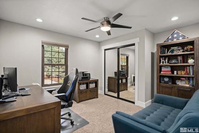 home office featuring light carpet and ceiling fan