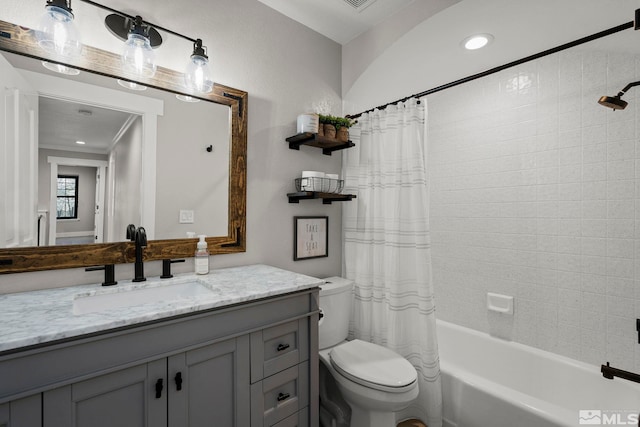 full bathroom with vanity, shower / bath combo with shower curtain, and toilet