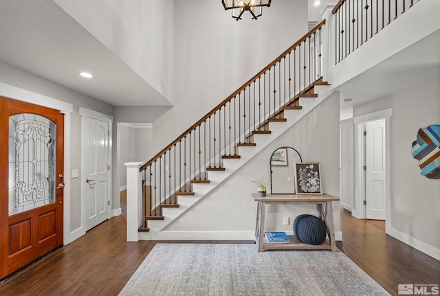 entrance foyer with a towering ceiling and dark hardwood / wood-style floors