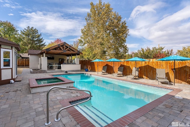 view of swimming pool featuring a patio area, a gazebo, and an in ground hot tub