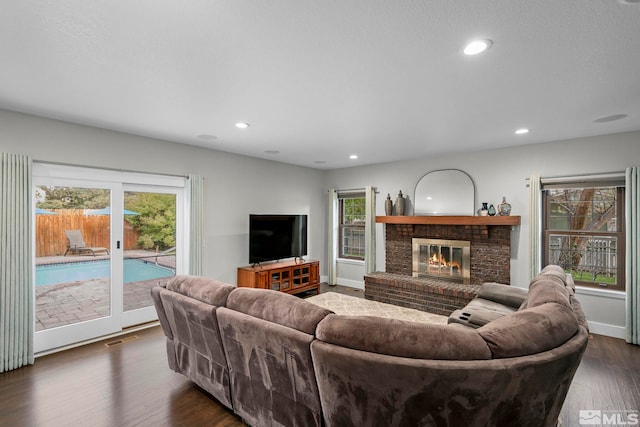 living room with dark hardwood / wood-style flooring and a fireplace