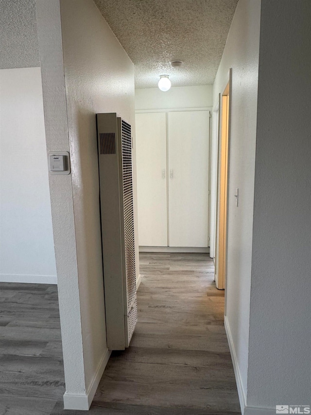 corridor featuring hardwood / wood-style flooring and a textured ceiling