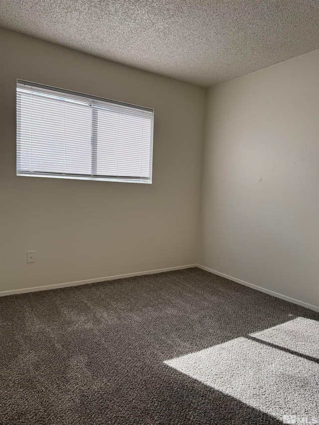 carpeted spare room featuring a textured ceiling