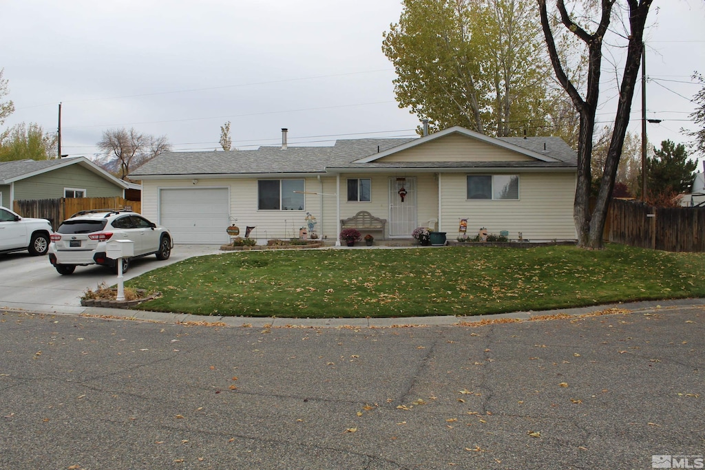 ranch-style home with a garage and a front lawn