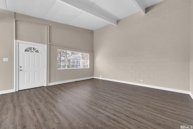 foyer featuring brick wall, dark hardwood / wood-style floors, and beam ceiling