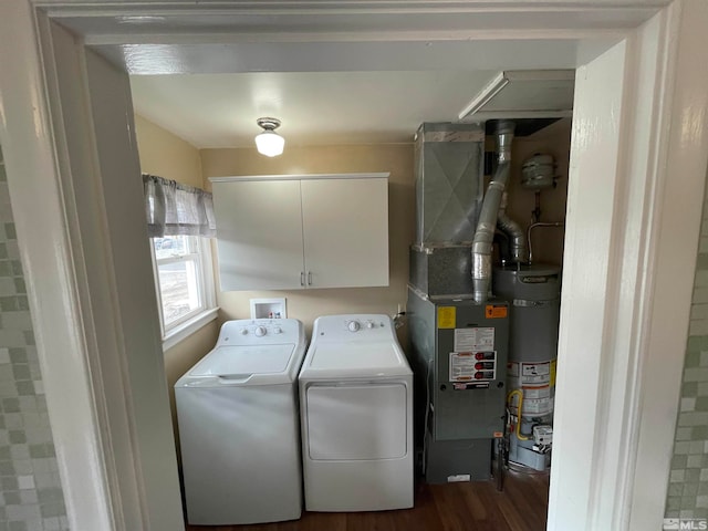 clothes washing area with cabinets, water heater, dark hardwood / wood-style flooring, and independent washer and dryer