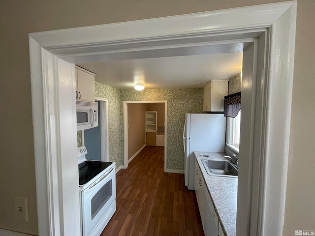 kitchen featuring white cabinets, sink, white appliances, and dark hardwood / wood-style floors