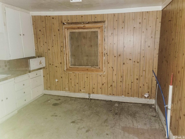 unfurnished room featuring light hardwood / wood-style floors and wooden walls