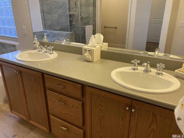 bathroom with walk in shower, vanity, and hardwood / wood-style flooring