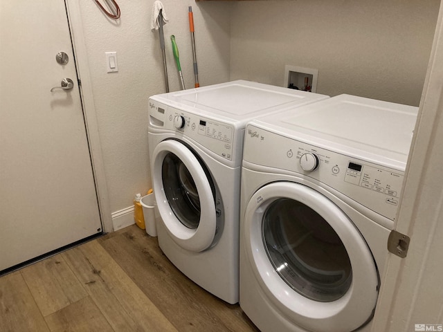 washroom featuring independent washer and dryer and light hardwood / wood-style flooring