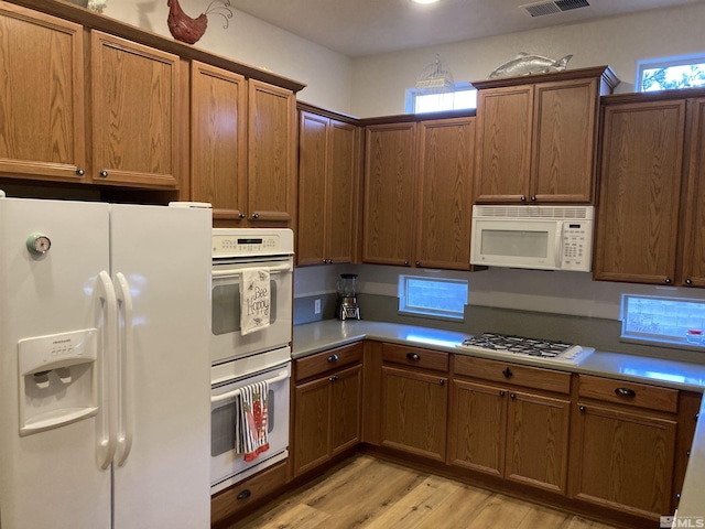 kitchen featuring light wood-type flooring and white appliances