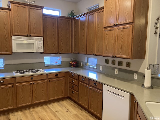 kitchen featuring white appliances and light hardwood / wood-style flooring