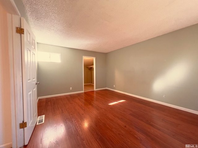 spare room with dark wood-type flooring and a textured ceiling