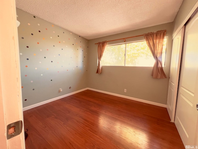 spare room featuring a textured ceiling and hardwood / wood-style flooring