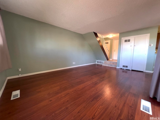 unfurnished room with dark wood-type flooring and a textured ceiling