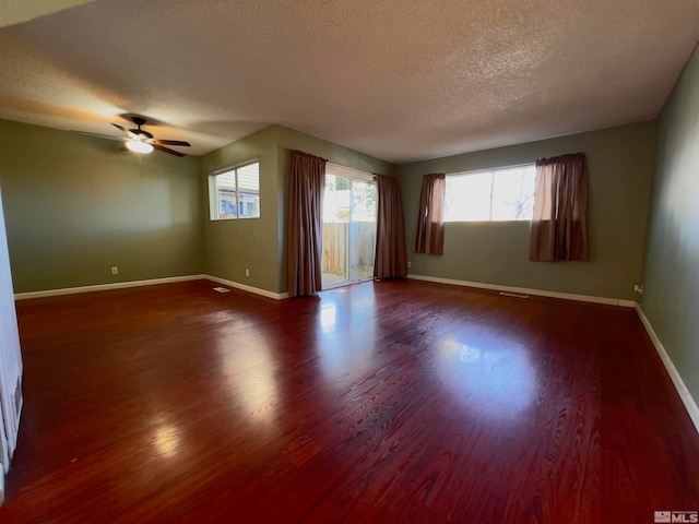 spare room featuring a wealth of natural light, wood-type flooring, and a textured ceiling