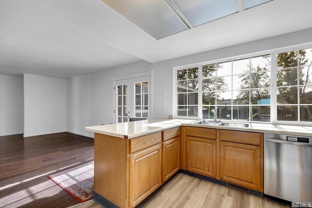 kitchen with french doors, light hardwood / wood-style floors, kitchen peninsula, sink, and stainless steel dishwasher