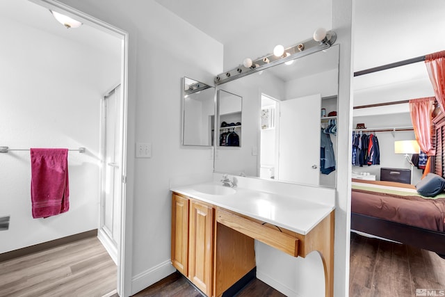 bathroom featuring hardwood / wood-style flooring, vanity, and an enclosed shower