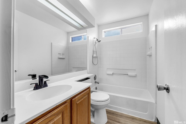 full bathroom featuring hardwood / wood-style floors, vanity, toilet, and tiled shower / bath