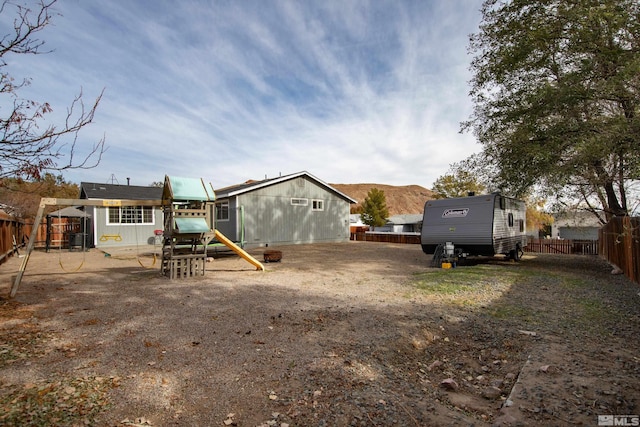 view of yard featuring a mountain view, a playground, and a patio