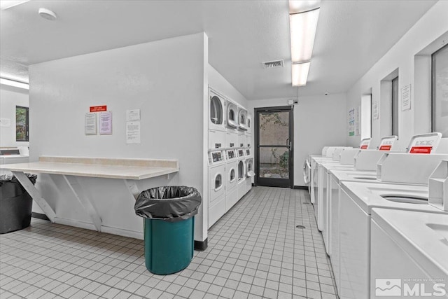 kitchen with white cabinetry, light tile patterned flooring, independent washer and dryer, and stacked washer and dryer