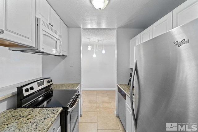 kitchen with a textured ceiling, white cabinetry, stainless steel appliances, and light tile patterned floors