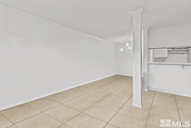 basement featuring a textured ceiling, light tile patterned floors, and crown molding