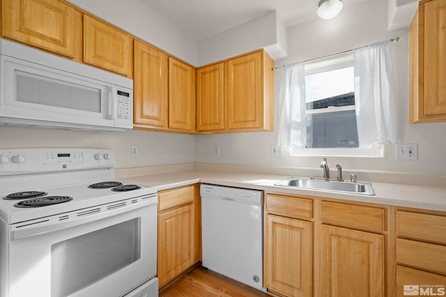 kitchen with light brown cabinets, light hardwood / wood-style floors, sink, and white appliances