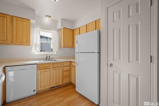 kitchen featuring light wood-type flooring, light brown cabinetry, sink, and white appliances