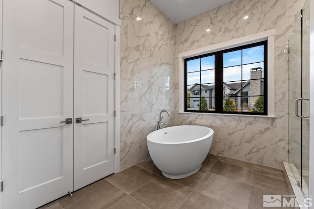 bathroom featuring independent shower and bath, tile walls, and tile patterned flooring