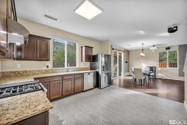 kitchen featuring light wood-type flooring, appliances with stainless steel finishes, ventilation hood, and plenty of natural light