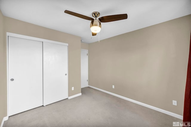 unfurnished bedroom featuring a closet, light colored carpet, and ceiling fan