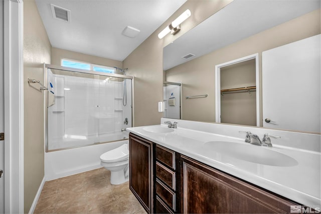 full bathroom with shower / bath combination with glass door, tile patterned flooring, vanity, and toilet