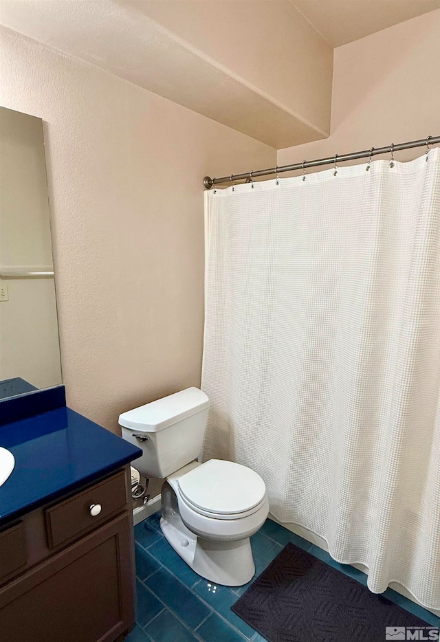 bathroom featuring toilet, vanity, and tile patterned floors