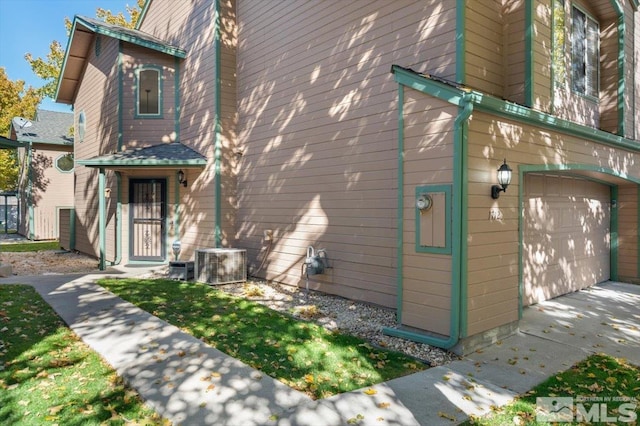 exterior space featuring a garage and cooling unit