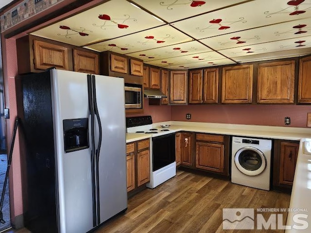 kitchen with appliances with stainless steel finishes, washer / clothes dryer, and dark wood-type flooring