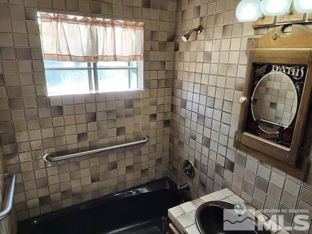 bathroom with tiled shower / bath and vanity